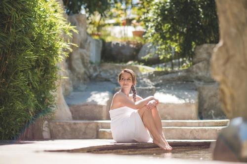 a woman in a white dress sitting on some steps at Hotel Mignon Meran Park & Spa in Merano