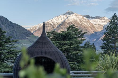 a building with a view of a mountain at Hotel Mignon Meran Park & Spa in Merano