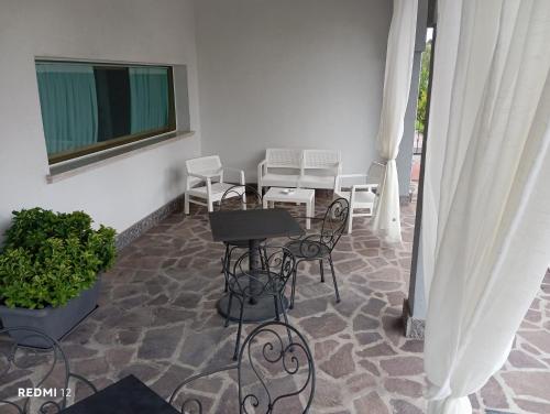 a patio with a table and chairs on a floor at BF SUITE Foresteria Bellusci in Rho