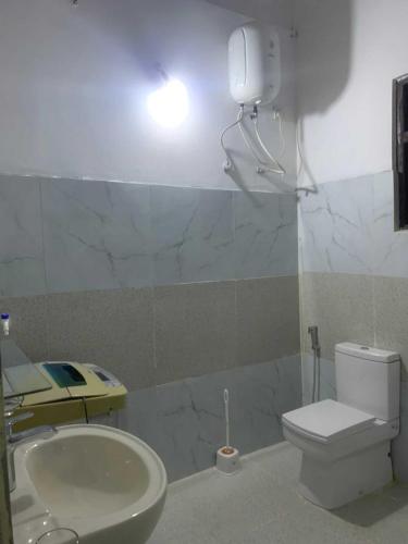 a bathroom with a toilet and a sink and a light at Lakshmi Villa in Aluthgama