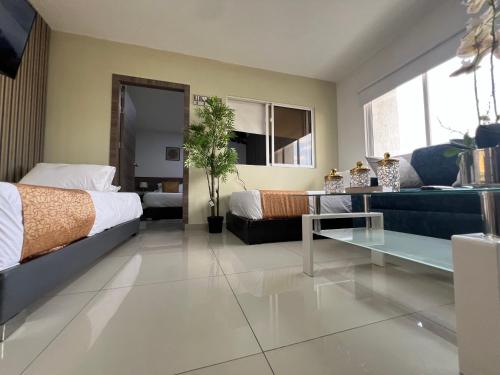 a bedroom with a bed and a couch at Aparta Suites La Flora- Infinity Living in Cali