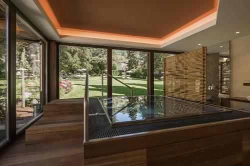an indoor aquarium in a house with a large window at Hotel Mignon Meran Park & Spa in Merano