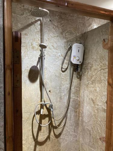a shower in a bathroom with a blow dryer at Bangka Hostels in El Nido