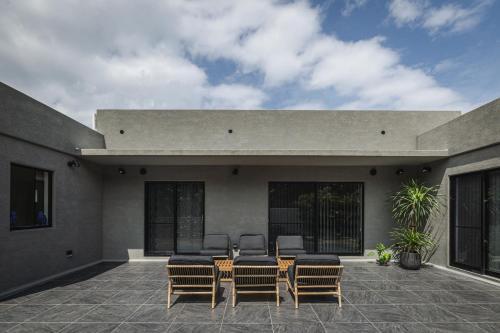 a patio with chairs and tables on a building at THE HERO VILLA 米原ビーチリゾートishigaki in Ishigaki Island