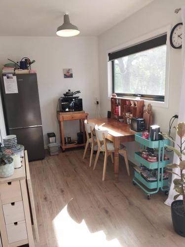 a kitchen with a wooden table and a refrigerator at Studio Solaris in Daylesford