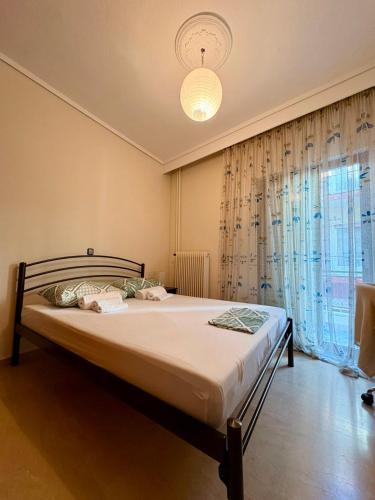 a bed in a bedroom with a large window at Mυρσίνη in Komotini