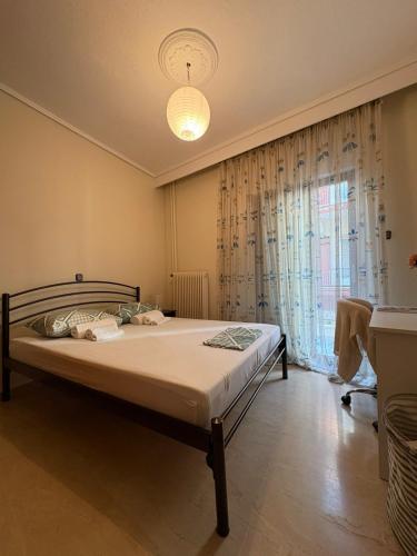 a bedroom with a bed and a large window at Mυρσίνη in Komotini