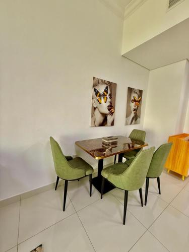 a dining room with a table and green chairs at Spacious Luxury Lagoon View 2Bhk in Dubai