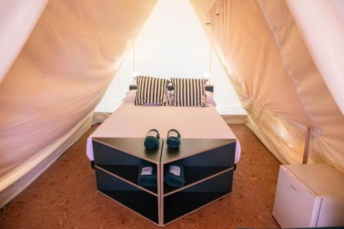 a bed in a tent with shoes on it at Tres Estrellas in Gavà