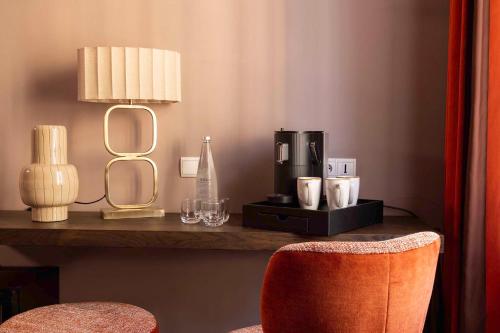 a room with a table with a coffee maker and a chair at Hotel Trianon Rive Gauche in Paris