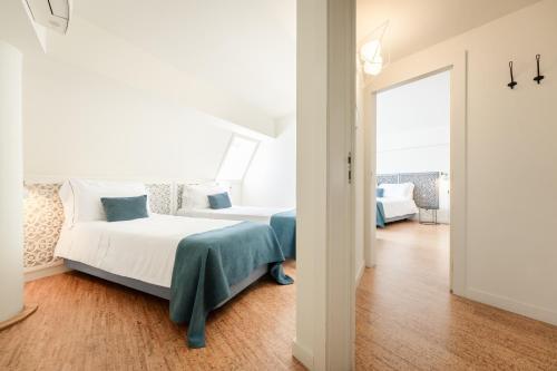 a white bedroom with a bed and a window at Galerias Nightlife Fashion Flats in Porto