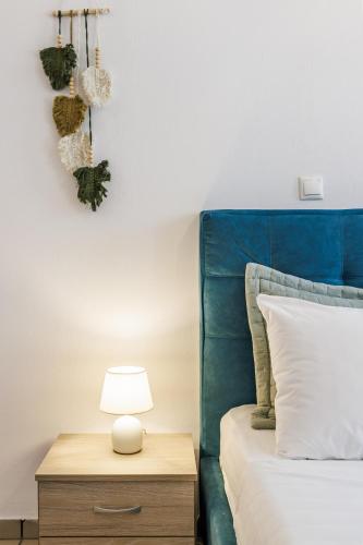 a bed with a blue headboard and a table with a lamp at Heaven House in Skopelos Town