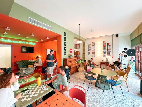 a group of people sitting in a room with a table at Ostello Bello Bologna in Bologna