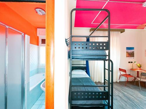 a bunk bed with a ladder in a room with a tub at Ostello Bello Bologna in Bologna