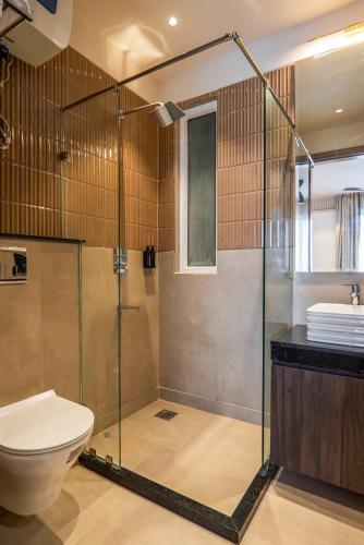 a bathroom with a shower and a toilet at Micasa Suites in New Delhi