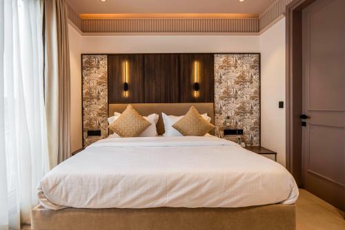 a bedroom with a large bed with white sheets at Micasa Suites in New Delhi