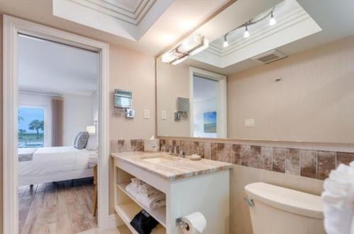 a bathroom with a sink and a toilet and a bed at Sanibel Inn in Sanibel