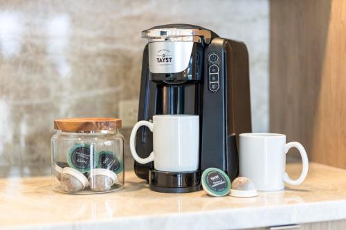 a coffee maker sitting on a counter with two cups at Sanibel Inn in Sanibel