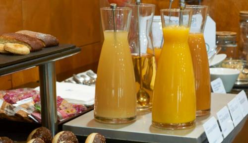three glasses of orange juice sitting on a table at NH Ciutat de Reus in Reus