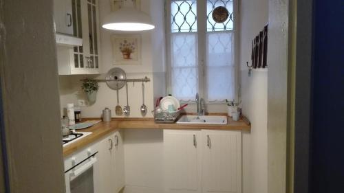 eine weiße Küche mit einem Waschbecken und einem Fenster in der Unterkunft Residenza Se son Rose in Schignano