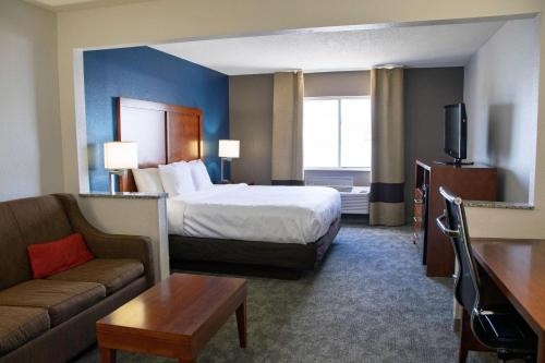 une chambre d'hôtel avec un lit et un canapé dans l'établissement Comfort Inn & Suites Coralville - Iowa City near Iowa River Landing, à Coralville