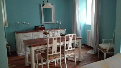 ein Esszimmer mit einem Tisch und weißen Stühlen in der Unterkunft Residenza Se son Rose in Schignano