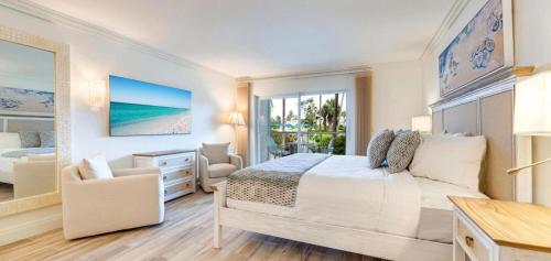 a bedroom with a bed and a desk and a chair at Sanibel Inn in Sanibel
