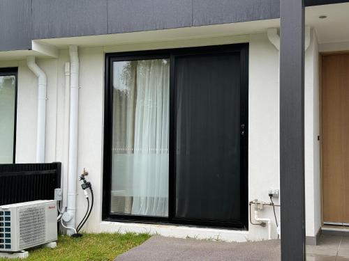 a sliding glass door on the side of a house at Mooroolbark 火车站附近的阳光大床房 in Mooroolbark