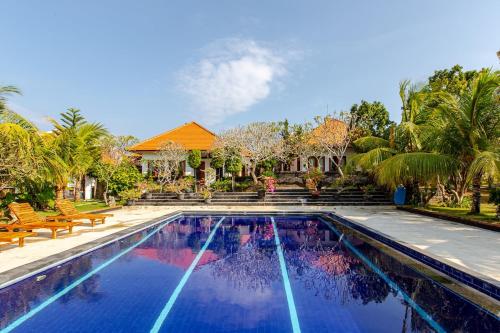 a swimming pool in front of a house at Villa Lumbung Uluwatu 2 in Uluwatu