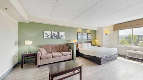 a hotel room with a bed and a couch at Sleep Inn & Suites Buffalo Airport in Cheektowaga