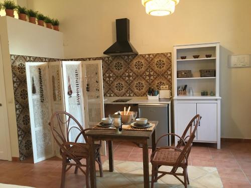 a dining room with a table and chairs and a kitchen at Darcilla Guest House in Tarifa