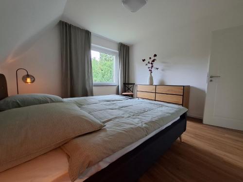 a bedroom with a large bed and a window at Bright 3-room apartment - space for family & friends in Tecklenburg