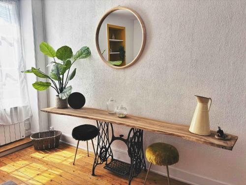 a table with stools and a mirror on a wall at Chez Kapameï in La Clayette