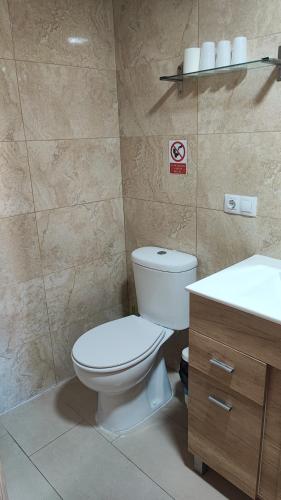 a bathroom with a toilet and a sink at Boomerang Cottage B&B in Quintanapalla