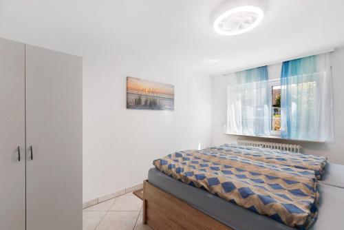 a bedroom with a bed and a window at Ferienwohnung Zeller in Gaienhofen