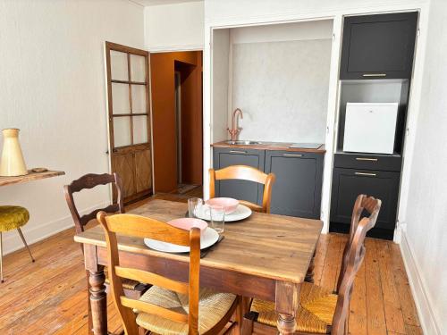 a dining room with a wooden table and chairs at Chez Kapameï in La Clayette
