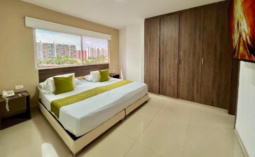 a bedroom with a large bed with a large window at Aparta Suites La Flora- Infinity Living in Cali