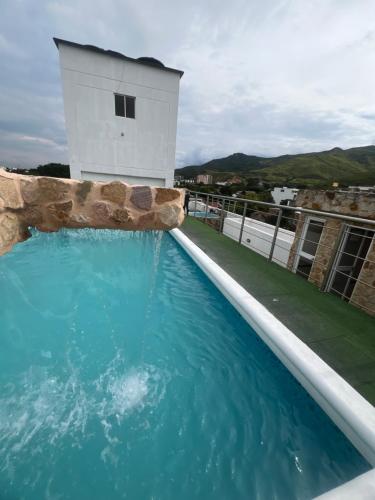 a swimming pool with a tower on top of a building at Aparta Suites La Flora- Infinity Living in Cali