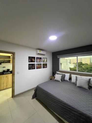 a bedroom with a large bed and a window at Aparta Suites La Flora- Infinity Living in Cali