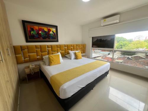 a bedroom with a large bed and a large window at Aparta Suites La Flora- Infinity Living in Cali