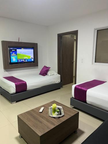 a hotel room with two beds and a coffee table at Aparta Suites La Flora- Infinity Living in Cali