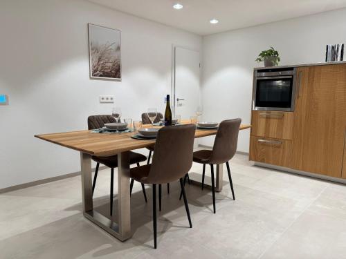 a dining room with a wooden table and chairs at DonauDeluxe in Geisingen