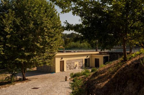 a building on a road next to some trees at Casa Ponte da Vessada in Celorico de Basto