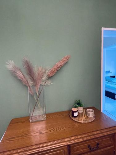 a vase with feathers on top of a wooden dresser at Preiswerte Wohnung nahe Düsseldorf inklusive Stellplatz in Haan