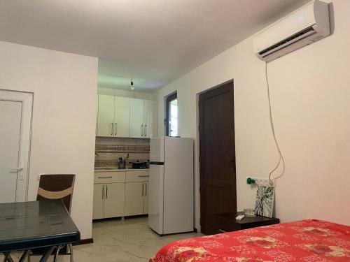 a kitchen with a table and a refrigerator in a room at BEATRIS in Ureki