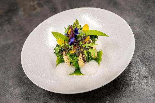 a white plate with a dish of food on a table at Hotel Mignon Meran Park & Spa in Merano
