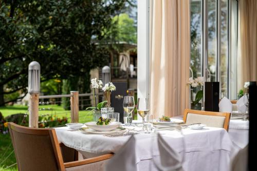 a table with white tablecloths and glasses of wine at Hotel Mignon Meran Park & Spa in Merano