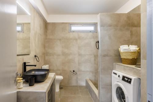 a bathroom with a sink and a washing machine at Heaven House in Skopelos Town