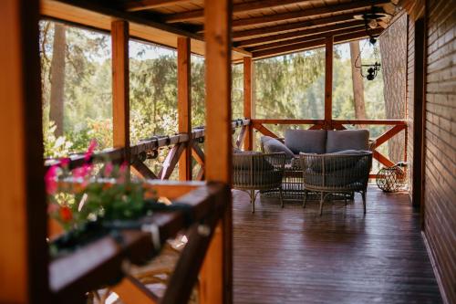 a screened in porch with chairs and a table at Dwa Pomosty in Augustów