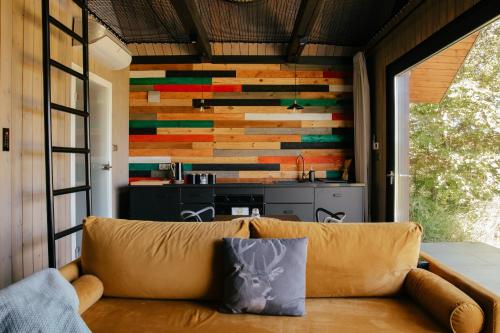 a living room with a couch in front of a wall of wood at Dwa Pomosty in Augustów